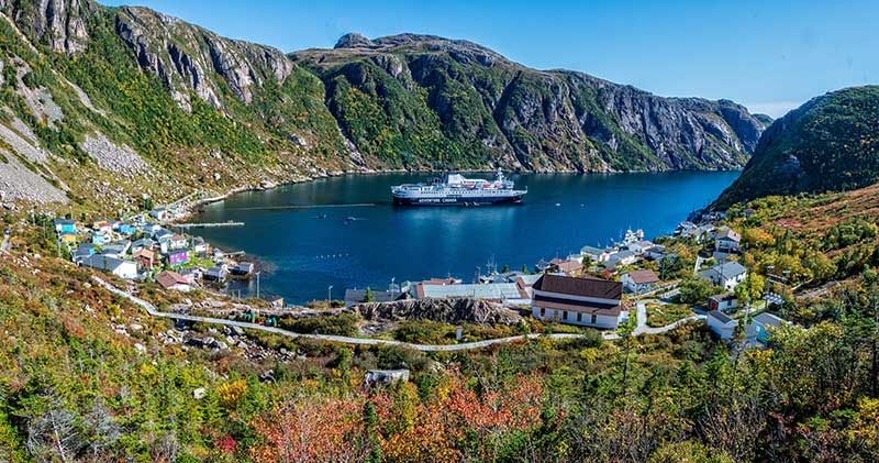 Adventure Canada - Ship in a bay with mountains in background