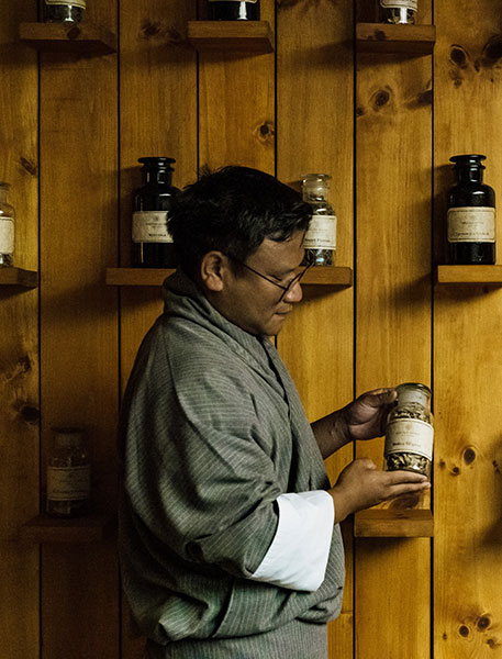 Man standing holding a jar of herbs for wellness - Bhutan Spirit Sanctuary, Paro