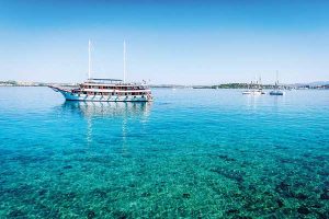 Boat sitting in teal clear water where you can see bottom - Croatian Island Explorer - Just Your